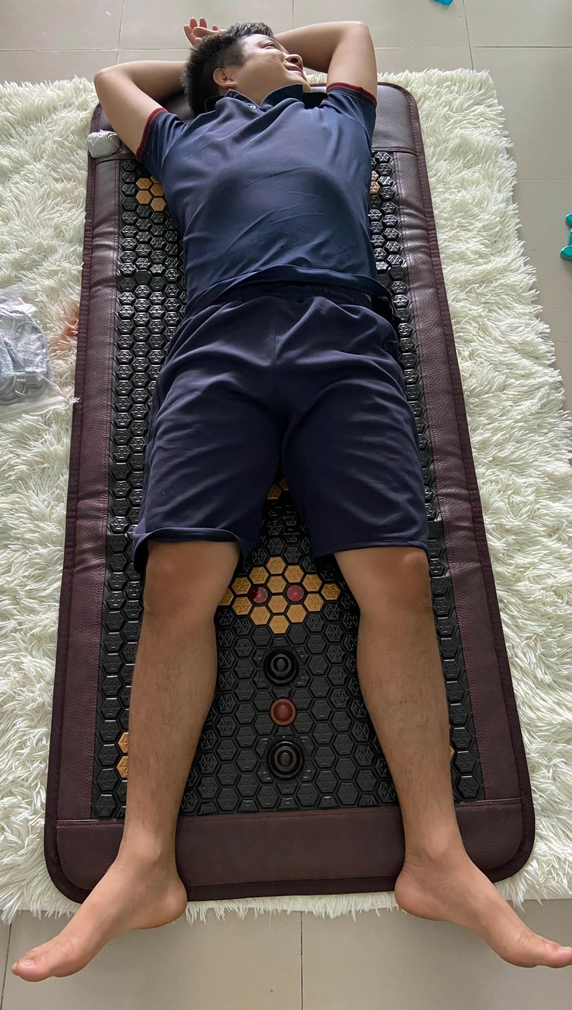 Người nằm trên thảm đá nóng cỡ lớn thư giãn toàn thân